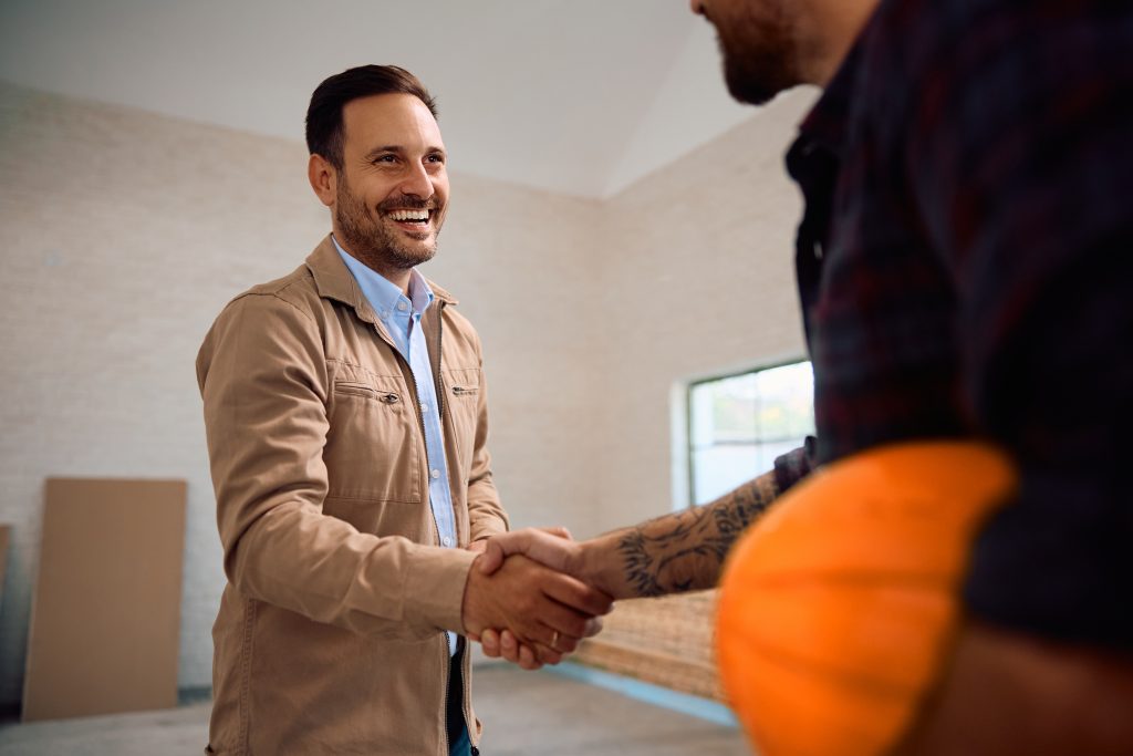image of happy client shaking hands with his builder